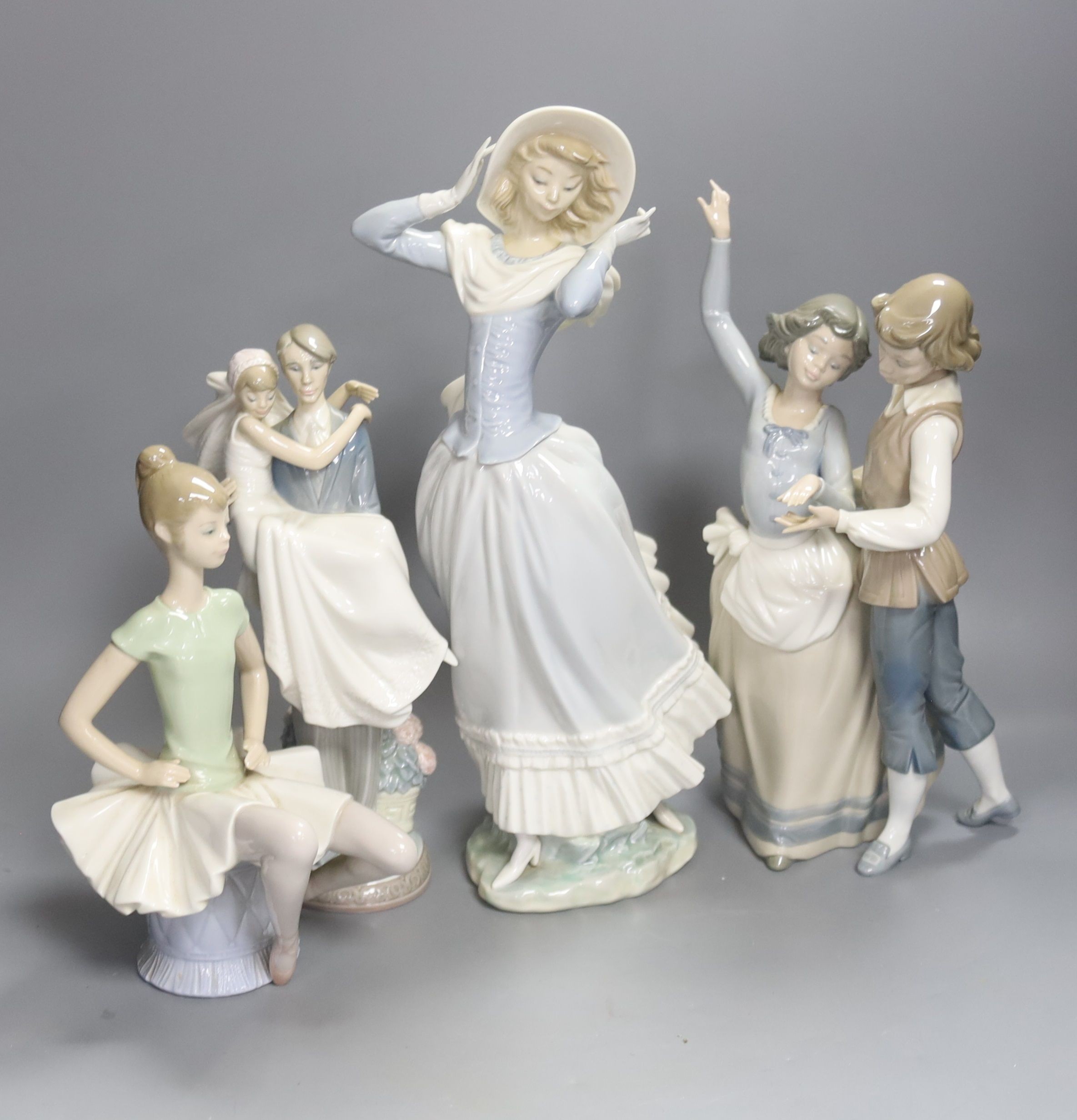 A Lladro figure of a ballet dancer, two dancers, newly-weds and lady in a bonnet, tallest 35cm